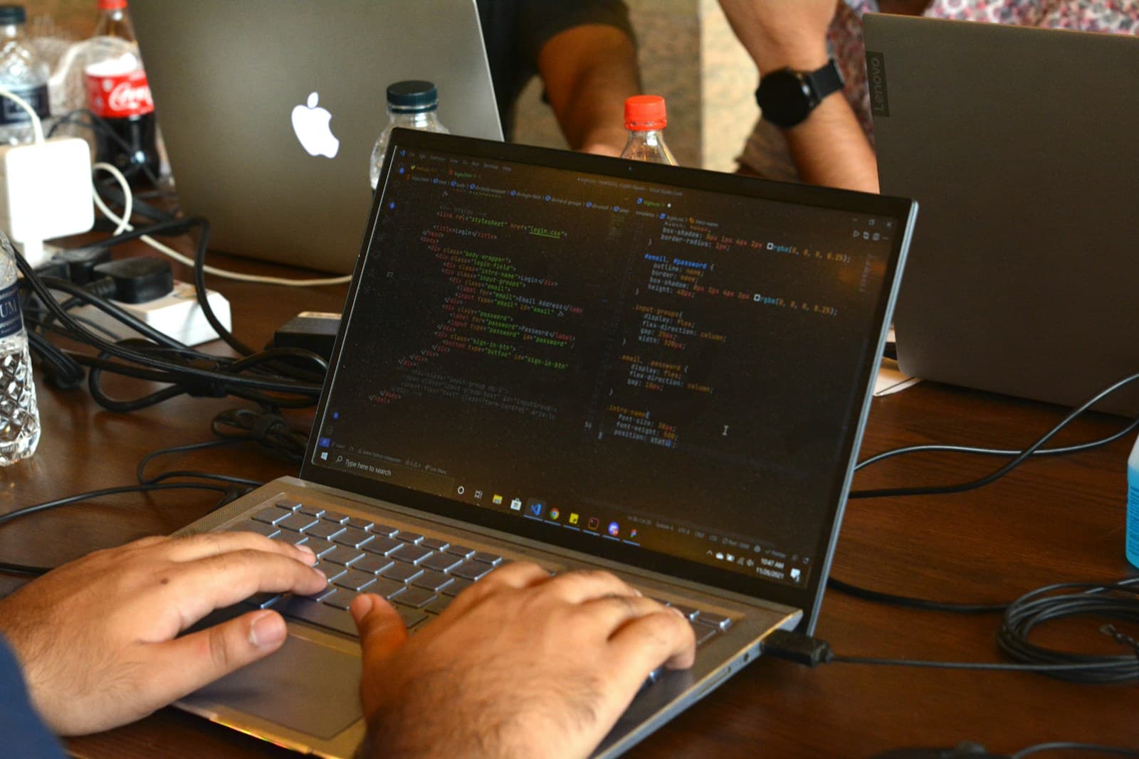 A developer writing code on a laptop at a hackathon